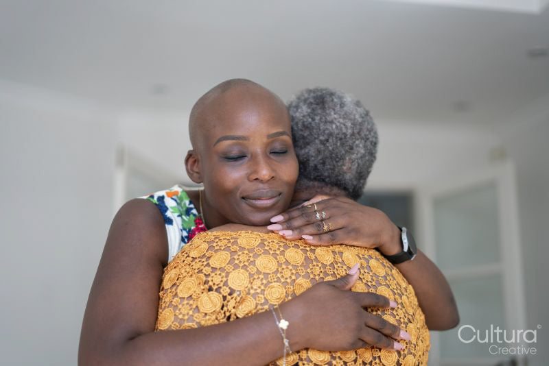 Smiling woman hugging mother at home