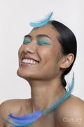 Blue feathers falling on smiling woman