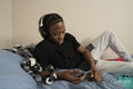 Teenage boy listening to music on bed at home
