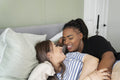Two young women embracing in bed