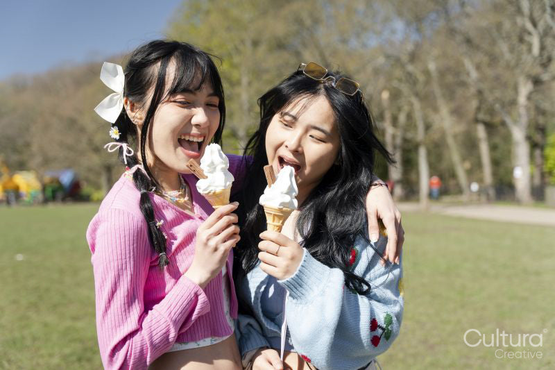 Young women eating ice cream in park