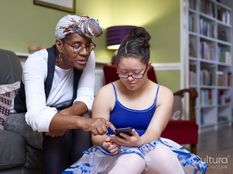 Mother and daughter with Down syndrome using smart phone