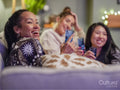 Friends watching television in pajamas in living room