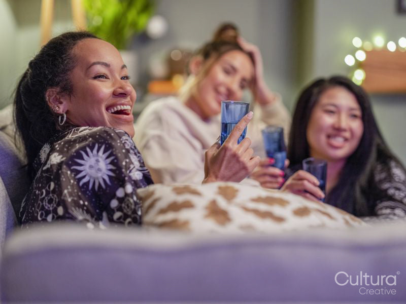 Friends watching television in pajamas in living room