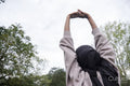 Rear view of woman in hijab stretching in park