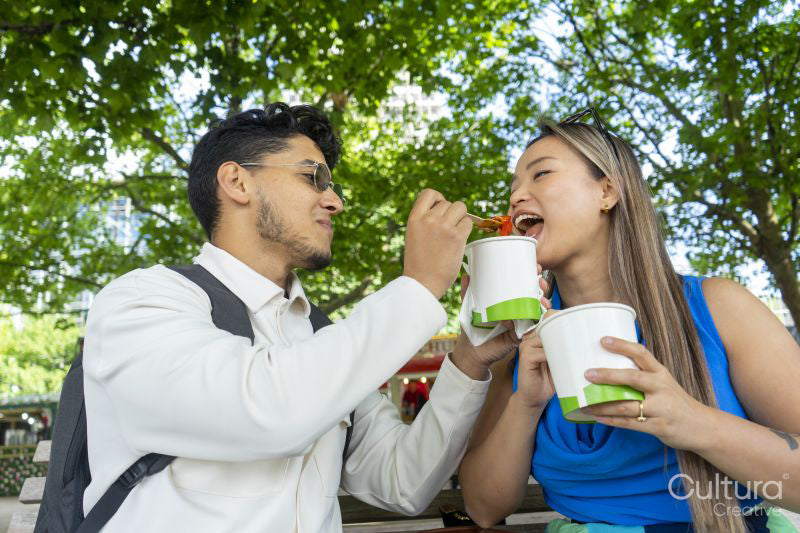 Tourist couple eating street food