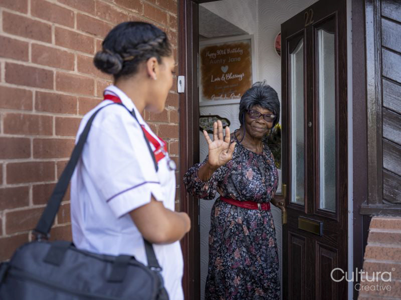 Nurse visiting elderly woman at her house