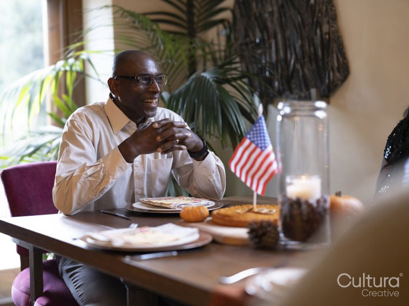 Smiling man sitting at Thanksgiving table