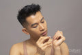 Studio shot of person applying beige nail polish