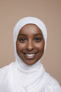 Studio portrait of smiling young woman wearing white hijab