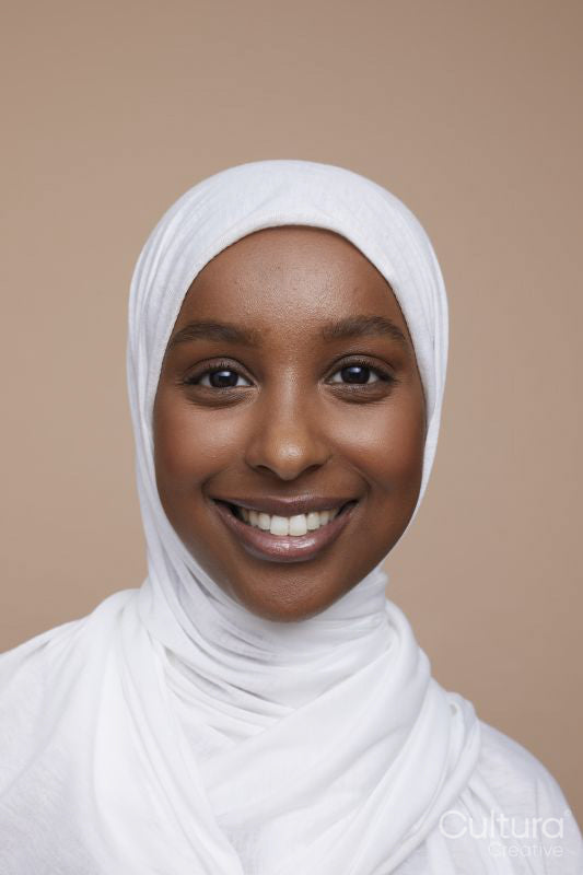 Studio portrait of smiling young woman wearing white hijab