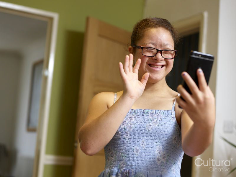 Girl with Down syndrome having video call on phone