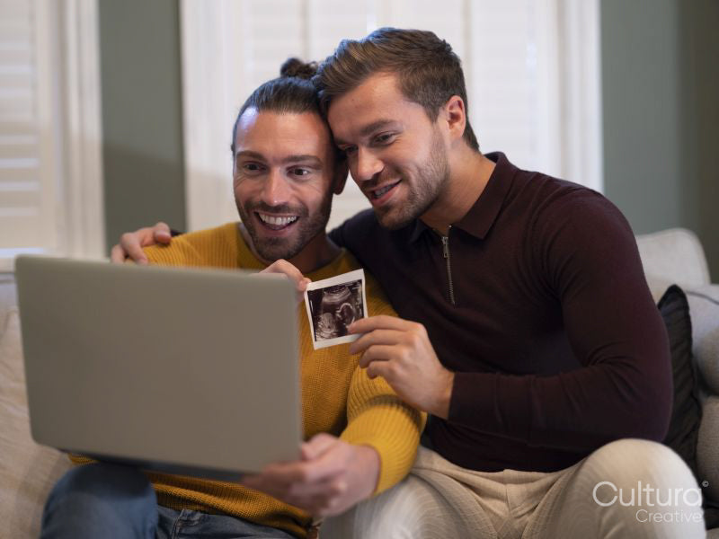 couple showing baby ultrasound on video call at home