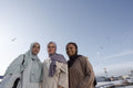 Portrait of three Muslim women standing on pier