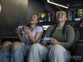 Female friends playing video games in gaming club