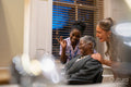 Smiling senior woman with nurse and hairdresser in hair salon