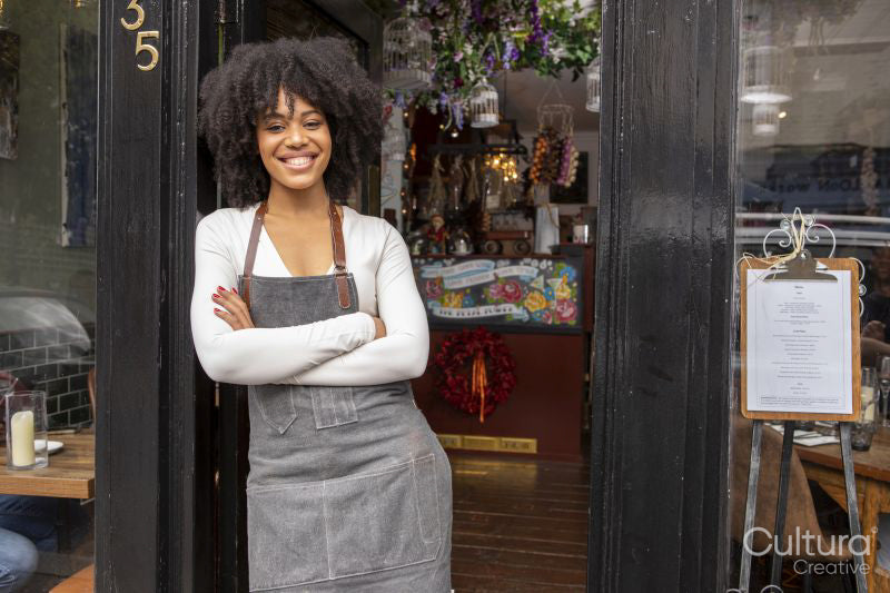 Portrait of smiling cafe owner at doorway