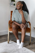 Portrait of young woman sitting in armchair at home