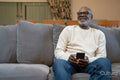 Senior man sitting on sofa and using phone