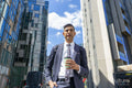 Businessman walking in business district with coffee
