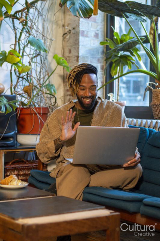 Man sitting on sofa and using laptop