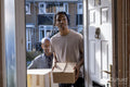 Father and son entering house with cardboard boxes