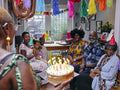 Multi-generation family celebrating birthday with birthday cake