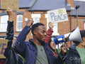 People on street holding protest signs with symbols of peace