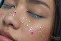 Close up of woman with closed eyes with colorful shiny freckles
