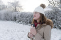 Smiling woman with bottle in winter landscape