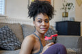 Smiling young woman holding water bottle at home