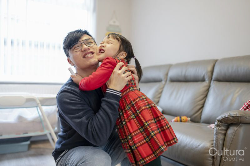 Girl hugging father in living room