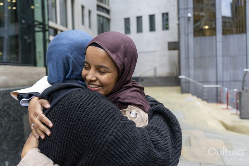 Two young women meeting in city