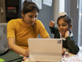 Mother homeschooling son using digital tablet
