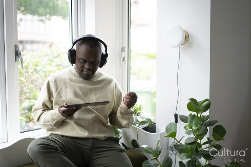 Man with Down syndrome using tablet and wearing headphones