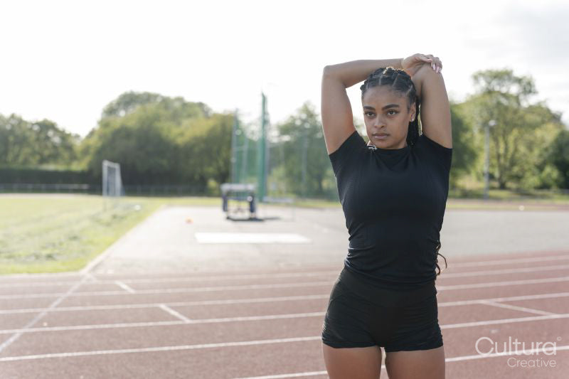 Female athlete stretching arms before training