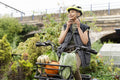 Smiling woman fastening helmet on cargo electric trike with homegrown vegetables