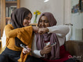 Female friends doing fist bump at home
