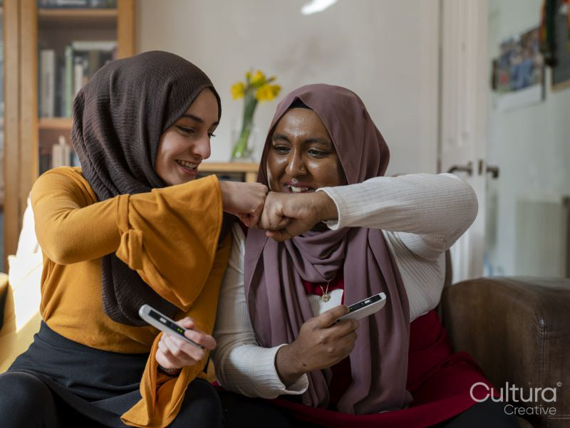 Female friends doing fist bump at home