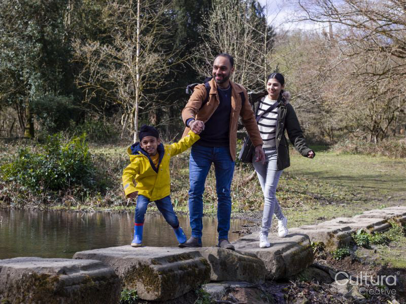 Parents with son on stepping stones in park