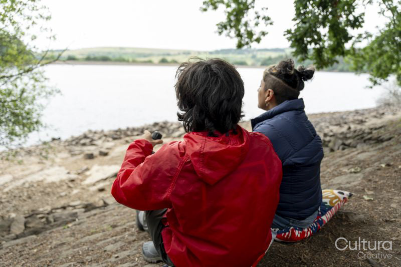 Mother and son relaxing by lake