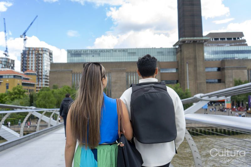 United Kingdom, London, Rear view of tourist couple on Millennium Bridge