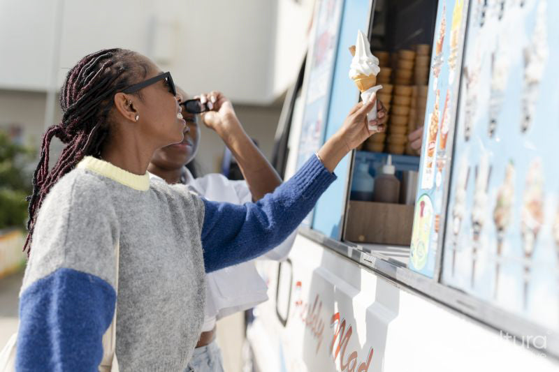 Young female friends buying ice cream in ice cream truck
