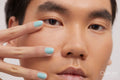 Studio portrait of handsome man with colored nails