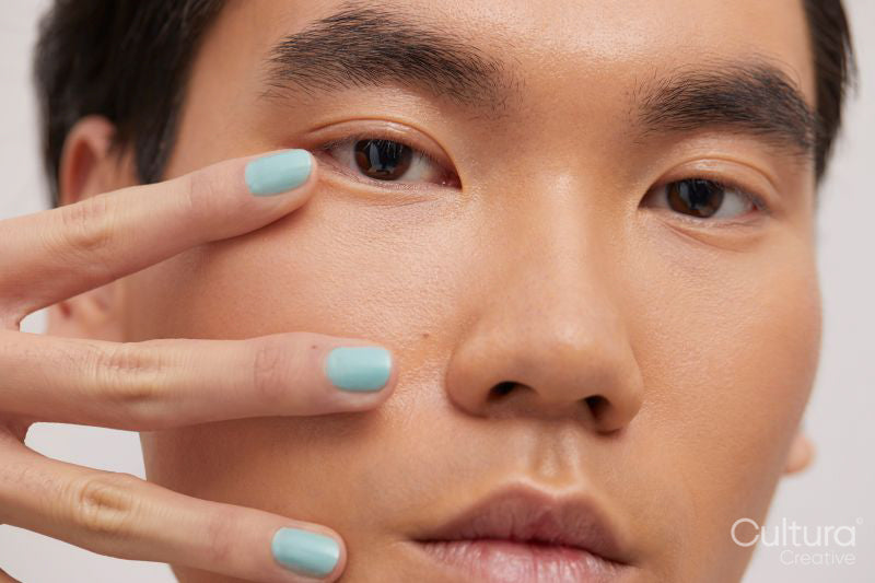 Studio portrait of handsome man with colored nails