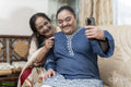 Woman and down syndrome granddaughter taking selfie in living room