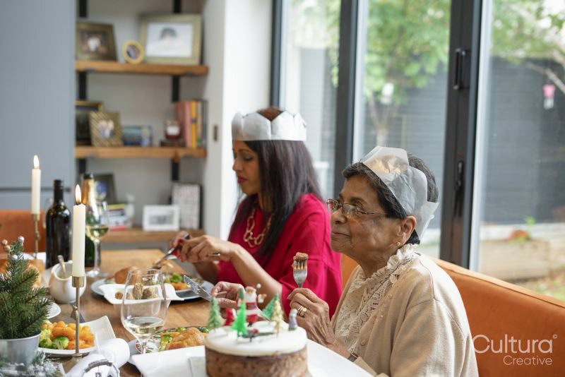 Women wearing paper crowns enjoying Christmas dinner