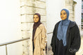 Two young women walking in street