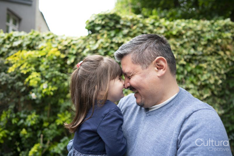 Smiling father and daughter rubbing noses outdoors