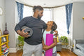 Father and daughter with yoga mats in living room